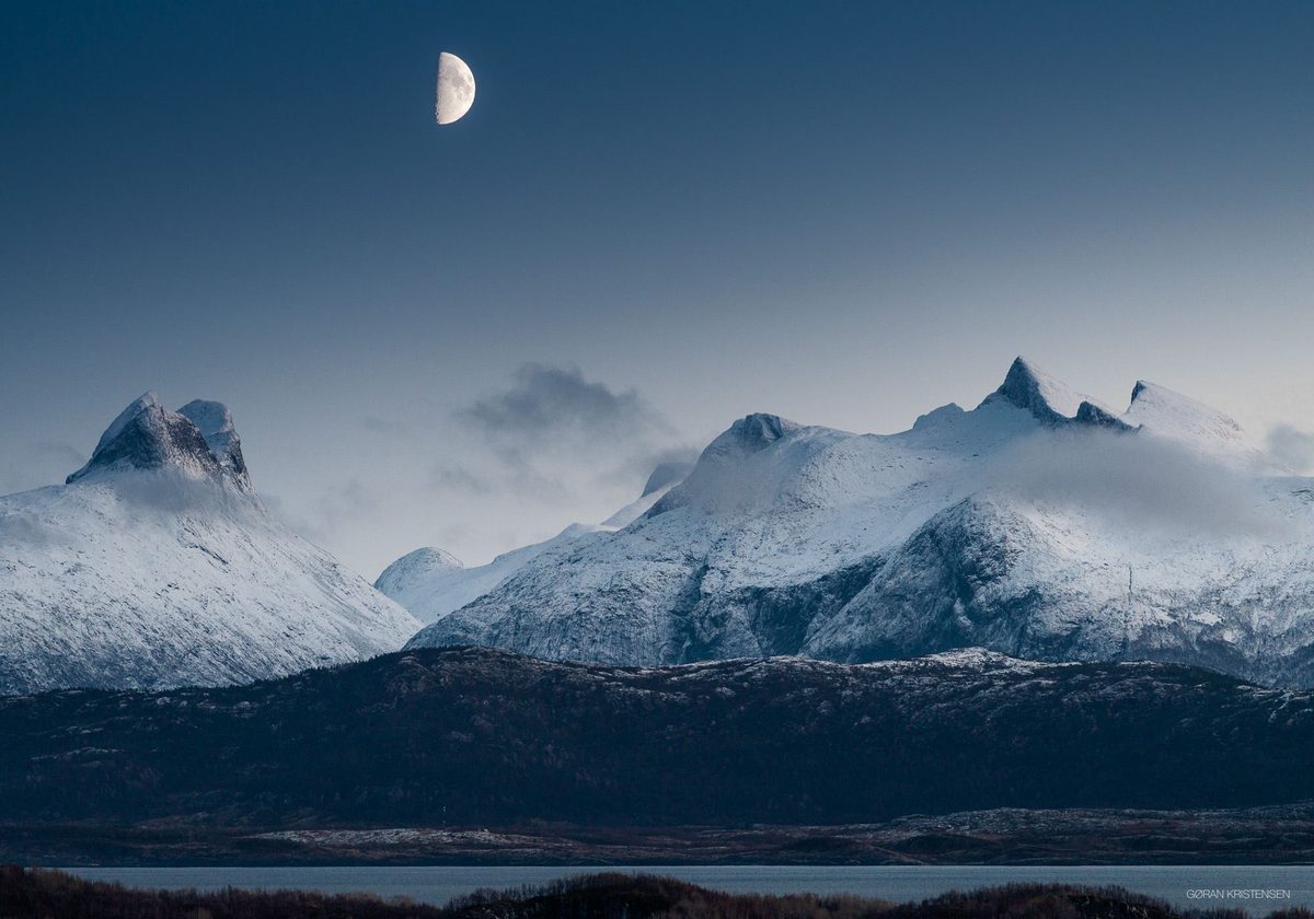 Halvmåne over snødekte fjelltopper