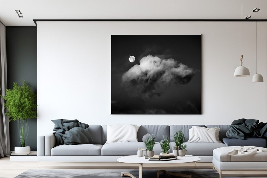 Svart-hvitt fotografi av månen bak en sky, i ramme på en stuevegg